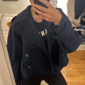 Kort trenchcoat  - Säljer min snygga marinblåa trenchcoat som jag köpte innan vintern men som endast använt fåtal gånger. Därav nyskick🩷