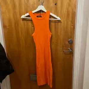 Orange klänning aldrig använd från bikbok. Storlek xs. Lappen kvar 