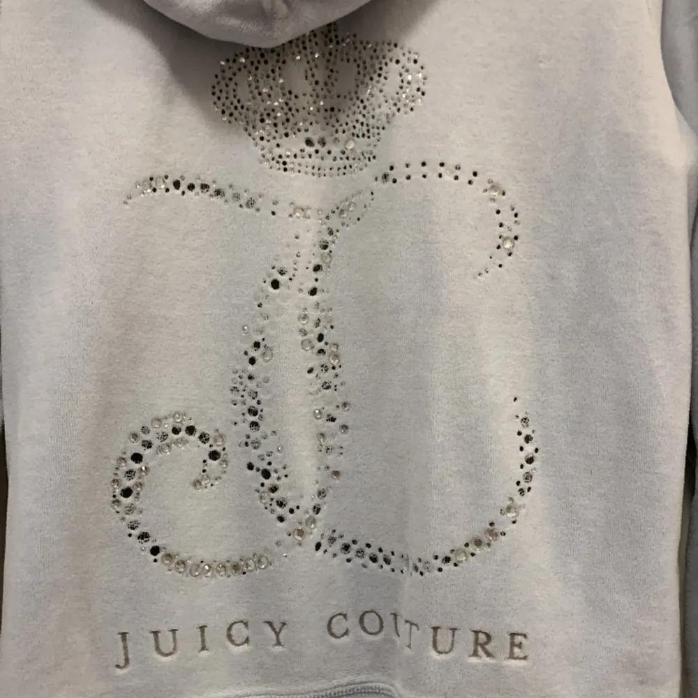 Ljusblå Vintage Juicy Couture hoodie i storlek M. Passar på mig som vanligtvis har storlek XS och är 158cm lång. Tröjan är i bra skick förövrigt men trycket är skadat. Hälften av stenarna på ryggen har ramlat av. OBS ENDAST SWISH💞. Tröjor & Koftor.