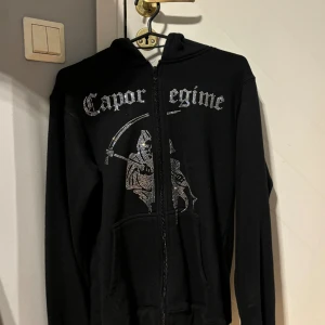 Rhinestone hoodie, cosanostra Stockholm  - En Rhinestone hoodie i storlek xs från cosanostra Stockholm. (Tillverkas inte längre). Skick 9/10. Kom med bud men kan även göra byten! 