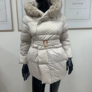 Kort vit dunjacka  - En kort dunjacka i vit färg med äkta vit/grå avtagbar päls. Jackan är helt ny och oanvänd och den finns i storlek S & L. Ord pris 2399kr