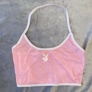 Topp  - En jättesöt rosa och vit croppad halterneck topp med en vit Playboy bunny på. Denna är köpt på plick från en tjej som själv gjorde tryck på tröjor! I storlek S. Pris kan diskuteras Skriv privat för mer bilder och info.