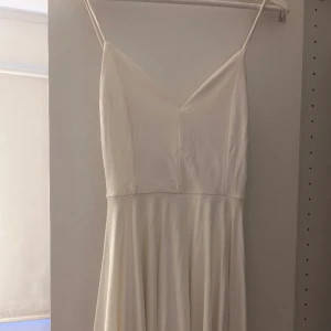 Studentklänning  - Student/skolavslutning- klänning. Vit klänning med en jättefin rygg. Klänningen är endast använd en gång och är i storlek XS köpt från bikbok
