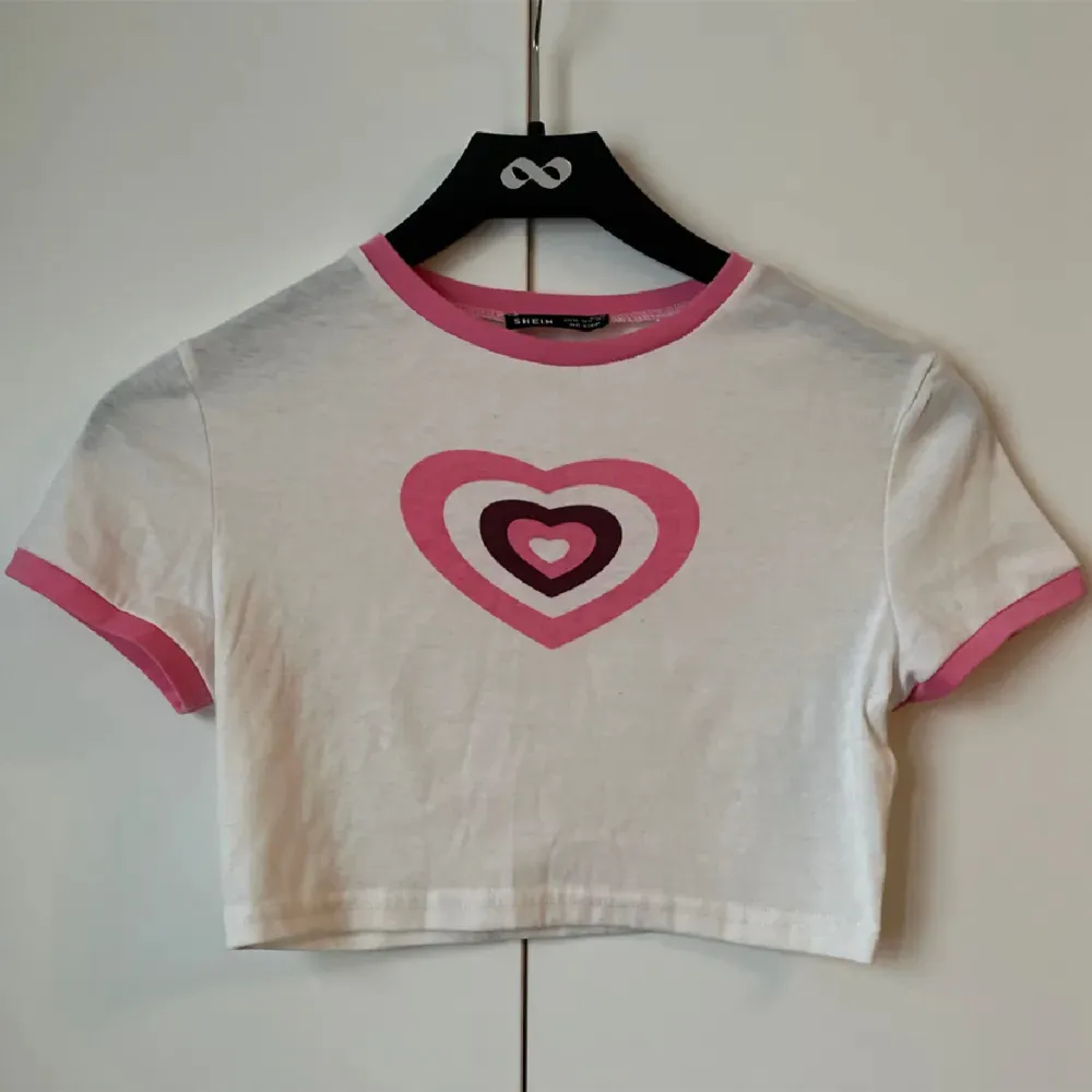 En babytee med ett rosa hjärta inspirerat från powerpuffpinglorna, från SHEIN i strl XS!💓. T-shirts.