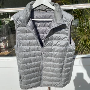 Uniqlo Väst i Silver Grå - Hej, säljer en sjukt snygg väst från Uniqlo i silvergrå färg. Använd mycket men i okej skick. Stilsäker och elegant, passar perfekt över en skjorta. Nypris 600kr. Storlek M. Pris kan alltid diskuteras! Hör av dig vid intresse! 