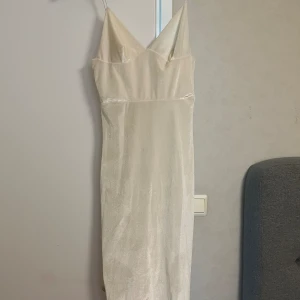 Klänning - Sammet material, creméfärgad Rebecca Stella klänning i storlek XS, sitter jättefint på kroppen och formar kurvorna fint