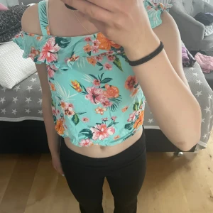 Färgglad blus - En väldigt färgglad tröja/blus. Den är i storlek 152 Men jag som egentligen har storlek 164 kan ha den bara att den är kort. Om man vill kan man köpa matchande shorts för fem kr.   Säljer för att jag inte gillar magtröjor och att den är för liten. 