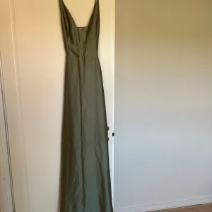 Satin klänning  - Fin grön klänning i satin, aldrig använd. Prislappen är kvar, storlek 36 