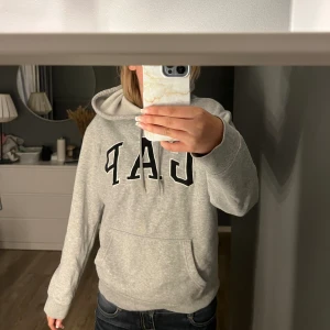 Fin grå hoodie från Gap - Super din grå hoodie från gap! Andvänd sparsamt och i fint skick. Säljer då jag inte längre andvänder den . Stolek xs