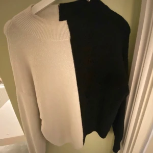 Svart och vit stickad tröja - Halva svart halva vit stickad tröja, saknar märke