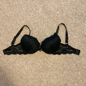 Svart spets BH - En svart spets BH i storlek 65F med push upp, den är i bra skick och inte mycket använd. Den är väldigt skön.  (Modellen på bilden har 75C)
