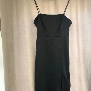 Kläningar  - Jag säljer denna svarta kläning🤍den är lång med en öppning på sidan ❤️den är helt oanvänd ,användes en gång och inte mer än det ❤️