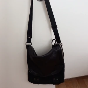 Väska - En väska med två fickor inne och ovanför kan man öppna med en dragkedja och lägga saker i.