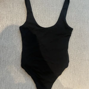 Svart body Bikbok  - Vanlig svart body tröja från Bikbok med öppen rygg och knappar nertill. Använd en gång. 