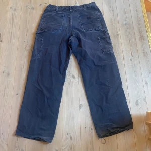 Carhartt jeans - Feta blåa jeans från carhartt. Har ett hål på smalbenet och lite fläckar annars inga defekter