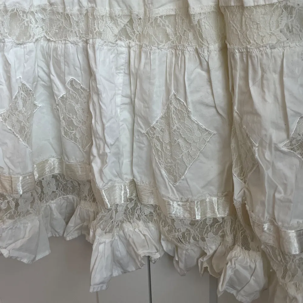 Fin mellenlång vit volang kjol i mycket bra kvalitet🥰. Perfekt nu till sommaren😍.  Midjemått rakt över:39cm. Kjolar.