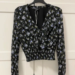 Svart blus - En väldigt fin svart blus med blåa blommor på💙