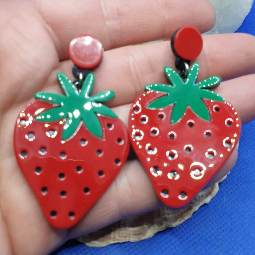 Den här örhänget föreställer jordgubbar / Jordgubbe med måtten är ca7 ×4 cm. Material av metall och akryl. Otroligt snygga örhängen av hög kvalitet.  Grymt snygga örhängen, oanvända, nyskick. Accessoarer.