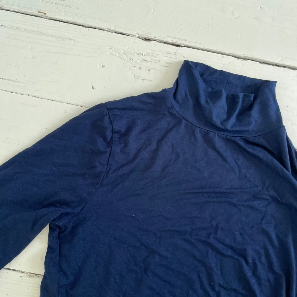 Mörkblå långärmad tröja med liten krage. Materialet är tunt och skönt. Tröjor & Koftor.