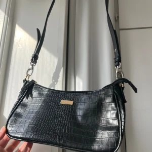 Svart väska med långt axelband - I nyskick, knappt använd väska. Jätte fin till vardags. Guld detaljer. Priset går att diskutera🌸