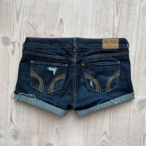 Lågmidjade hollistershorts - Lågmidjade jeansshorts från Hollister i storlek W27 L31 som jag har gjort om från ett par byxor. Tvärs över midjan är det ca 40 cm. Fint skick. Använd gärna köp nu!