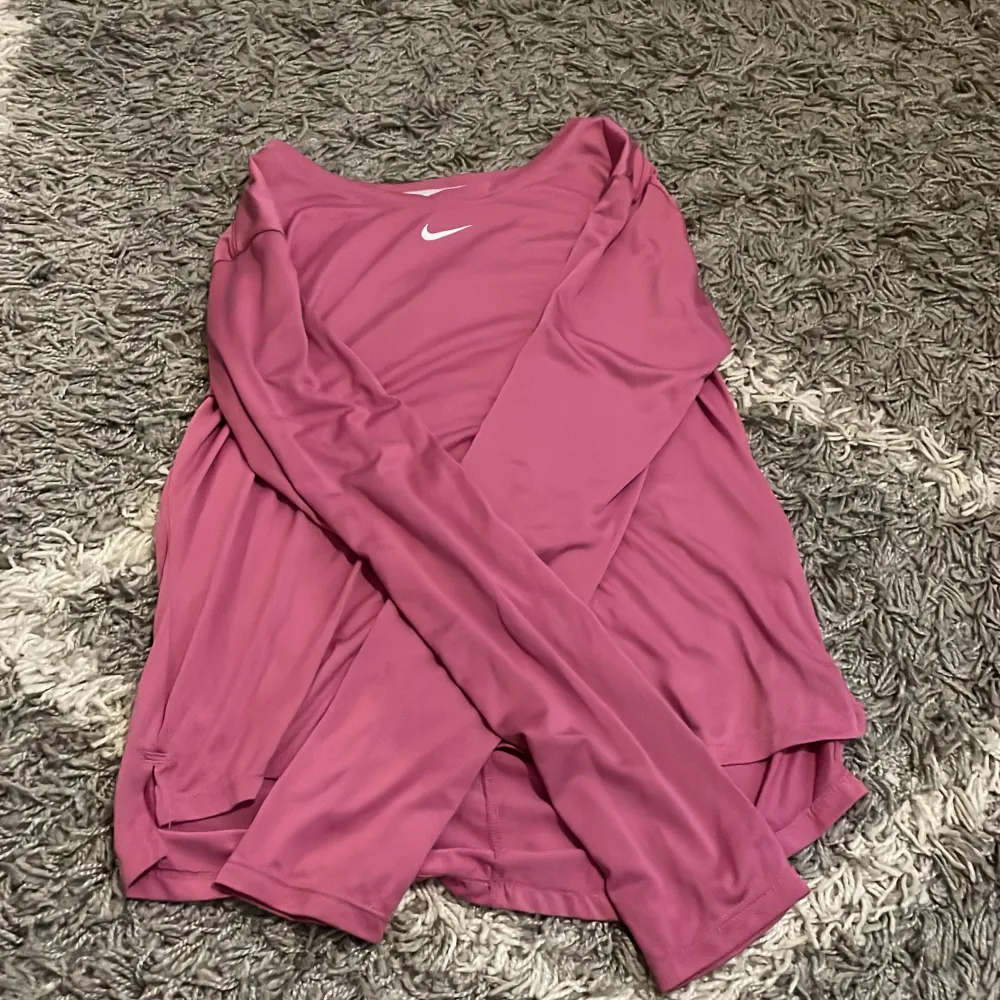 En rosa-lila långärmad träningströja från Nike i storlek XS. Tröjan är bara använd 1 gång. Jag säljer den för att den inte kommer till användning längre. Sport & träning.