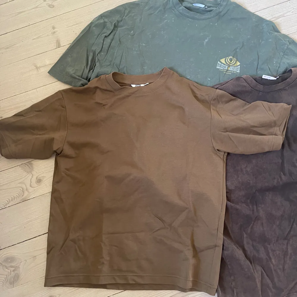 Två oversized t shirts från asos i den första bilden och en från uniqlo i den andra bilden. De från asos har logos på sig. Det finns en grön och en mörk brun från asos. Det finns en brun från uniqlo STRLK S.  Normal pris ca 350kr Jag säljer för 150kr. T-shirts.