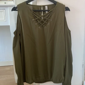 Grön blus - Grön blus med ”snören” framåt.
