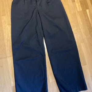 Kostymbyxor  - Hög midja, sydda veck framtill Lite pösiga, resår och hällor  80 % polyester 18 % viscose 2% elastan 