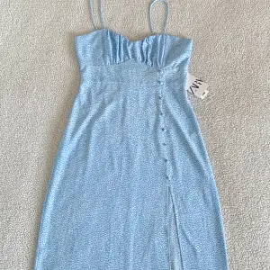 Otroligt vacker ljusblå klänning från ZARA med knappar och slits på sidan. Ny med tags kvar, utan anmärkningar.