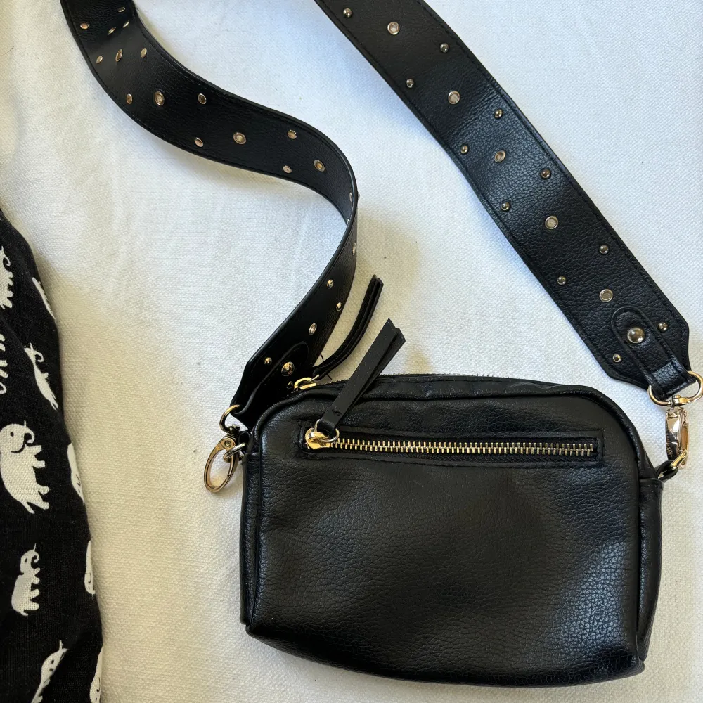 En svart liten väska från Lindex i bra skick. Den har ett avtagbart band som också kan användas till andra väskor💗. Väskor.