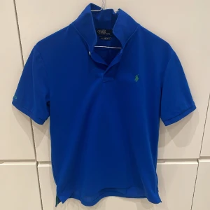 Polo Ralph lauren blå piké - Stilren pikétröja i en skön blå färg perfekt till våren. Skick 7/10 inte använd fler än 5 gånger. Pris kan diskuteras