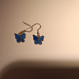 Örhängen  - Fina fjärilsörhängen med olika nyanser av blå.Den glimrar i ljus.