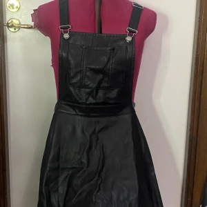 Hängsle kjol  - Köpt för ett par år sen men funkar bra fortfarande men inte helt i nyskick, finns en dragkedja på sidan. Själva kjolen är väldigt kort där back så man måste nästan ha någon under.  