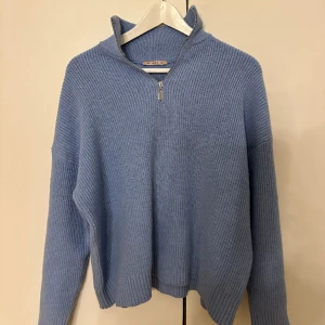 Blå stickad tröja - Säljer min fina stickade zip-up från Anna field då den inte kommer till användning💕 Den är i bra skick utom en tråd som sitter på ärmen (se bild).  Endast använd fåtal ggr. Nypris: 479kr  Strl: XS 