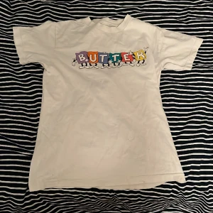 Butter Goods T-shirt - Snygg butter tröja som jag intr använder längre. Storlek S fast sitter mer som en Xs. Den har lite hål på framsidan (3 bilden) och en jötte liten svart fläck som man ser i första bilden. Om du har frågor om plagget eller vill ha mer bilder skriv Dm.