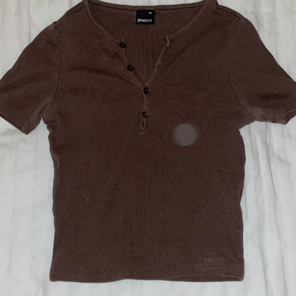 En brun färgad topp från Gina Tricot i storlek XS, köpt förra året. Den har använts många gånger men den har inte slitits, färgen har blivit lite urtvättad men den ser fortfarande bra ut. Säljer då den ej används längre . T-shirts.