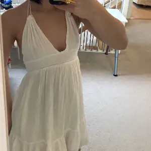En super super söt sommar klänning i vit som knyts i nacken jätte bra skick, används bara et få tal gånger. Kontakta för flera bilder