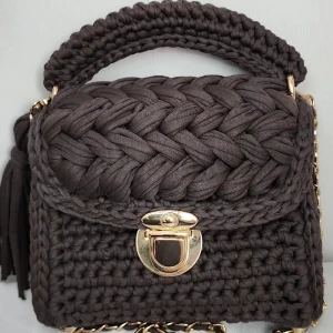 Handvirkad Väska  - Handvirkad väska av zpagetti garn i brun färg (har gjort den själv). Är rymlig samt tjusig. Passar till det mesta.  Om du vill ha i en annan färg eller storlek, tveka inte att skicka ett meddelande. Produkten är i djur och rökfritt miljö. 