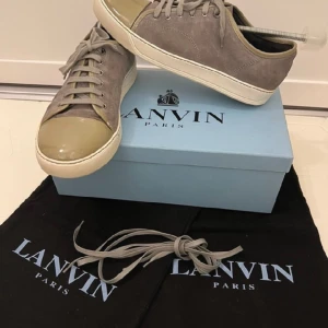 Lanvinn skor - Patent Cap Toe Sneaker (låda, kvitto, dustbag) - Ett par fina skor från Lanvin i storlek 42. De är i väldigt bra skick och kommer med låda, dustbag õ dig. kvitto. Kvalitén på skorna är obeskrivlig. Vid fler frågor eller funderingar tveka inte att kontakta oss. Passa på!