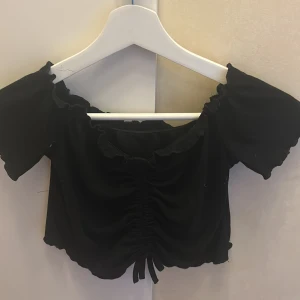 En svart kort tröja  - Tröjan är från SHEIN, Använd, den är väldigt kort,