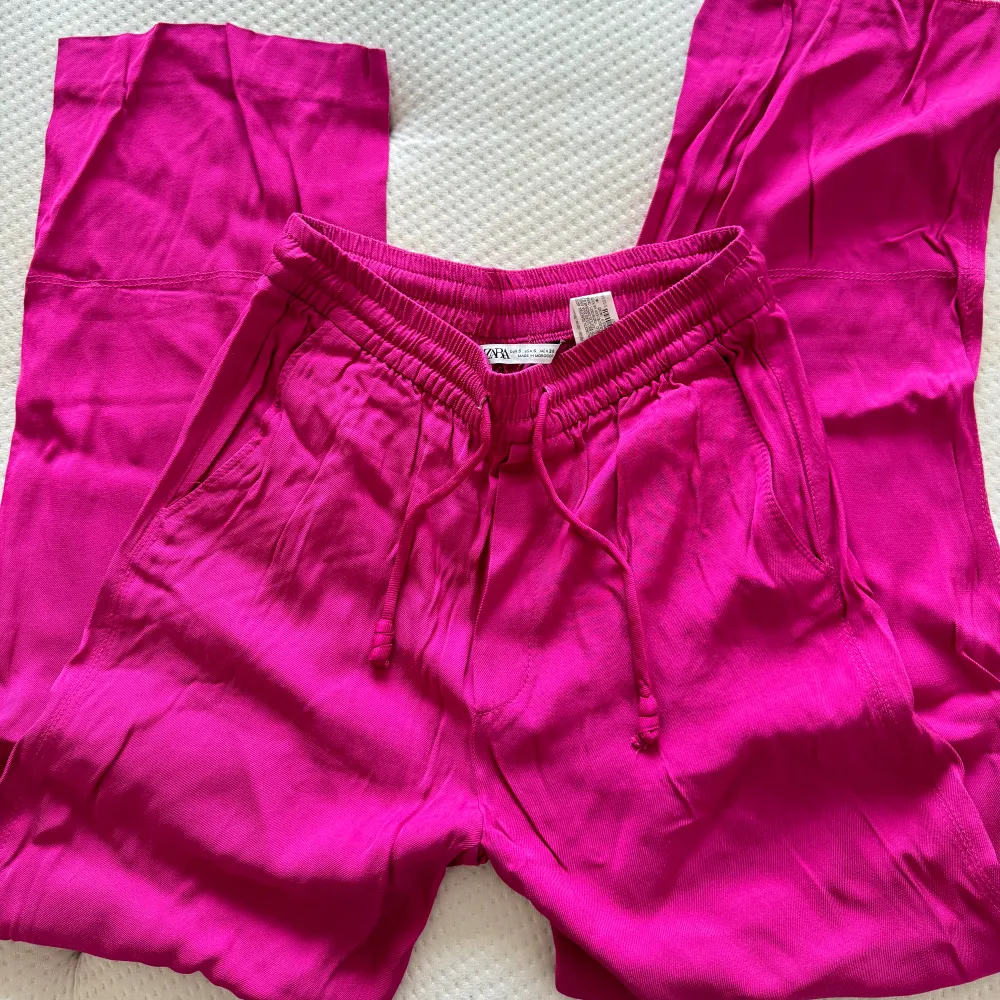Säljer dessa snygga rosa byxor från zara. Använda några få gånger och sitter bekvämt på. Sömnen på ena sidan av byxan behövs sy in, det är inget som märks av utan endast om man vill/orkar❤️‍🔥. Jeans & Byxor.