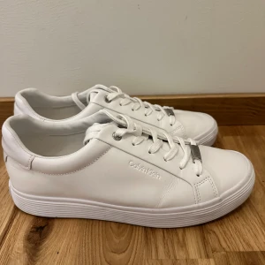Calvin Klein sneakers  - Vita Calvin Klein sneakers i storlek 41. Använda ytterst fåtal gånger