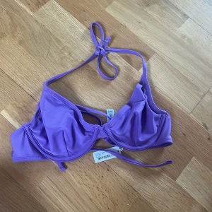 Bikiniöverdel  - Oanvänd lila bikiniöverdel med lappen kvar. Väldigt liten i storleken. 