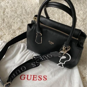 GUESS väska - Säljer min Guess väska (Felix Small Gilfriend Satchel) som ej finns kvar att köpa. Jag köpte den på Guess i Täby centrum för ca 5 år sedan och har därför inget kvitto. Dust bag finns! Bra skick men vissa tecken på användning finns. Ca 20x30 cm