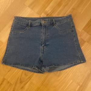 Stretchiga shorts ifrån H&M. Shortsen har hög midja, gylf med dragkedja och knapp. Fuskfickor fram och riktiga bakfickor. Kort slits på båda sidorna.