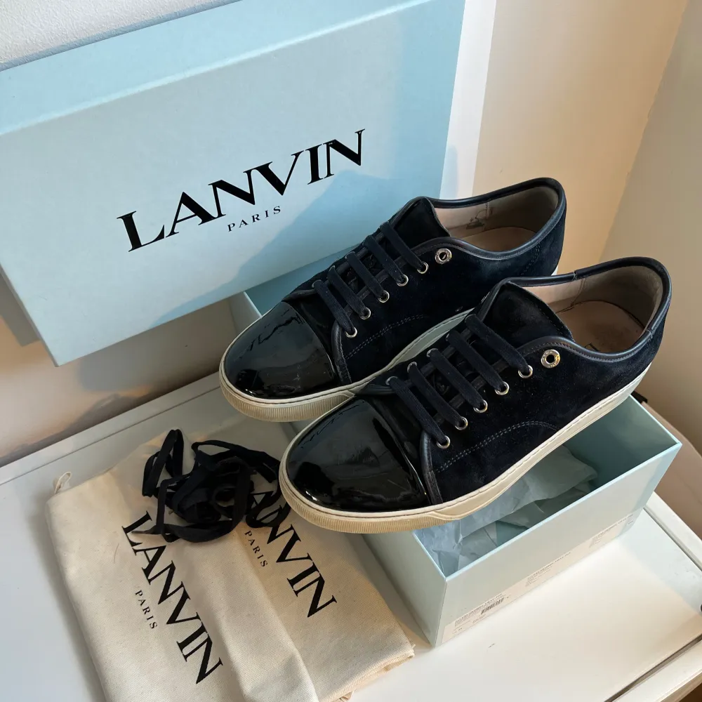 Hej! Säljer dessa sjukt snygga Lanvin skor. Dom är i mörkblå färg med svart glansig captoe. Bra skick, sulan är sliten. Storlek UK 8 vilket motsvarar 42/43. Box, dustbags och extra skosnören medföljer. Hör av er vid minsta lilla fundering. 🥂🍾👊🏻. Skor.