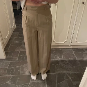 Visa byxor  - Beiga vida kostym byxor från NA-KD. Jätte fina och bekväma, storlek 34. Passar bra på mig som annars har storlek 36🥰