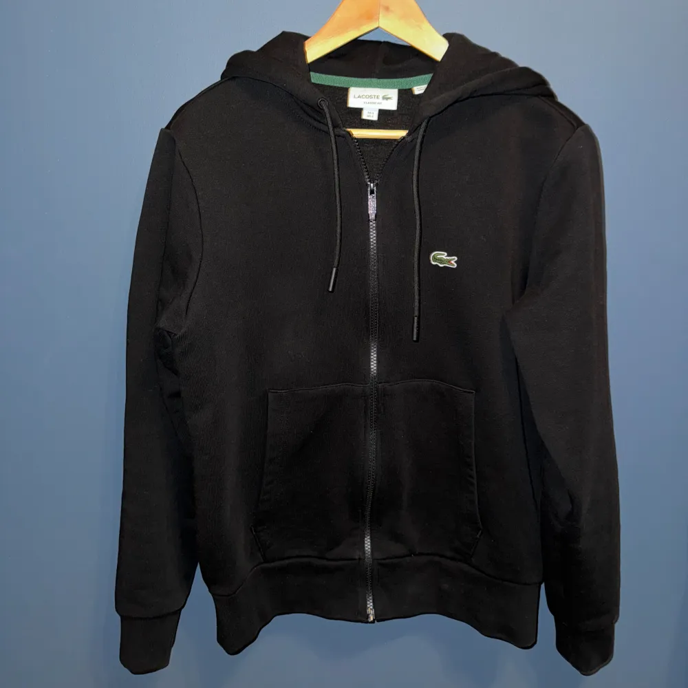 Lacoste Hoodie med dragkedja i stl S (FR 3)  Den är i bra skick (8/10) och köpt i USA Modellen är 180 cm Ordinarie pris är 1400kr Pris kan diskuteras! . Hoodies.