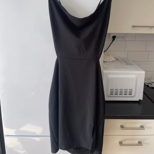 Klänning med slits  - Skitsnygg klänning med slits och knyt där bak, framhäver kroppen! Helt ny, använd en gång och inga defekter. 